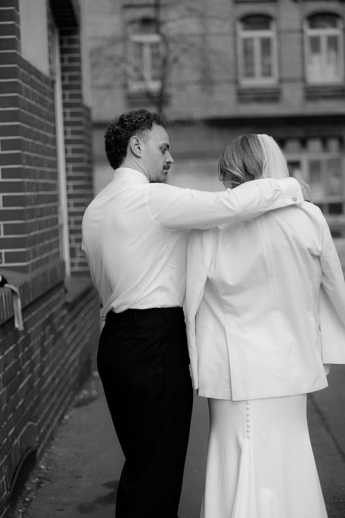 Bräutigam umarmt seine Frau in einem unbeobachteten Moment.
