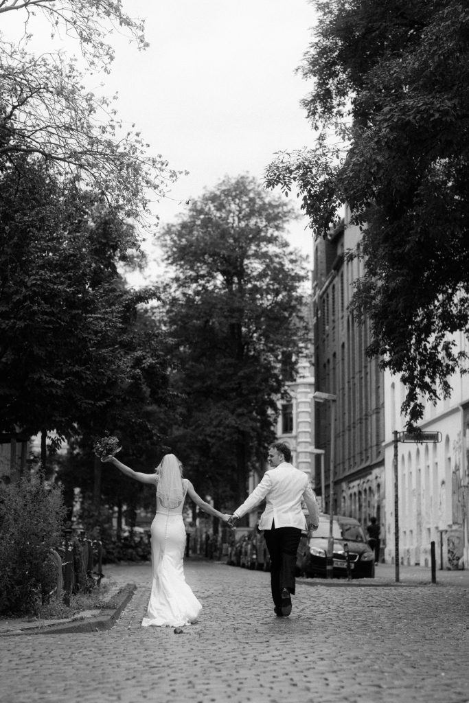 Ein Brautpaar im Brautpaarshooting laufend und ausgelassen. 